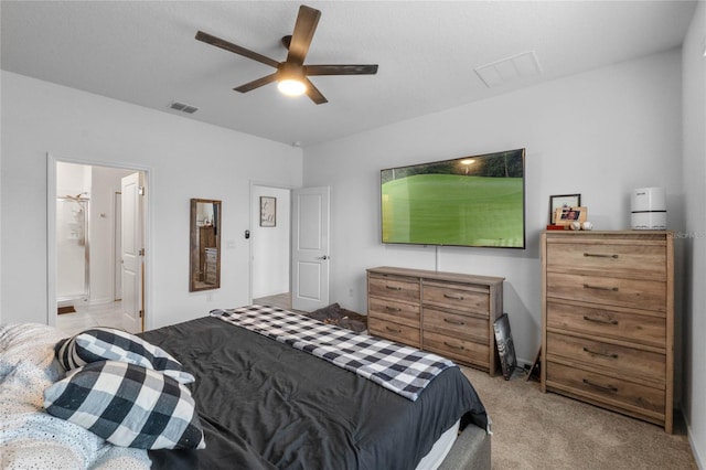 carpeted bedroom with ensuite bathroom and ceiling fan