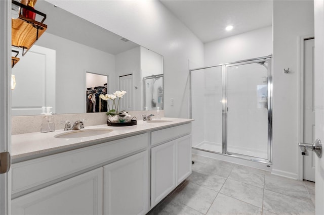 bathroom featuring tile patterned floors, vanity, and a shower with door