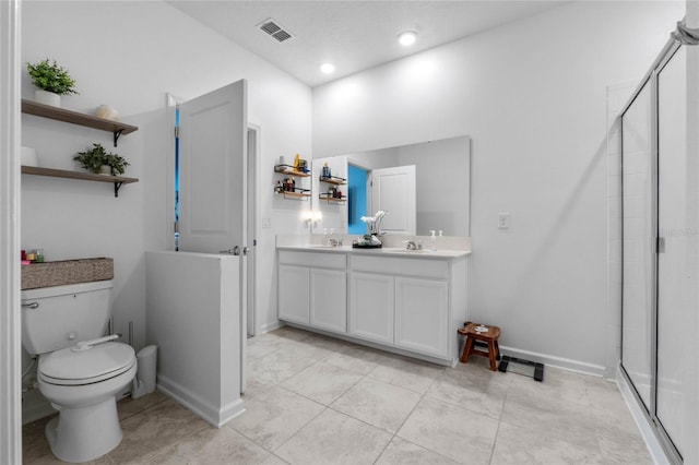 bathroom with tile patterned floors, vanity, toilet, and a shower with shower door