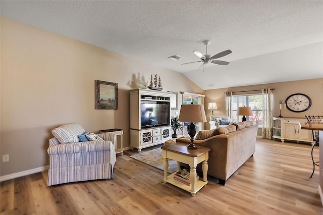 living room featuring a textured ceiling, light hardwood / wood-style flooring, ceiling fan, and lofted ceiling