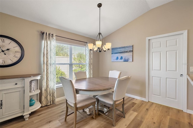 dining space featuring light hardwood / wood-style floors, lofted ceiling, and a notable chandelier