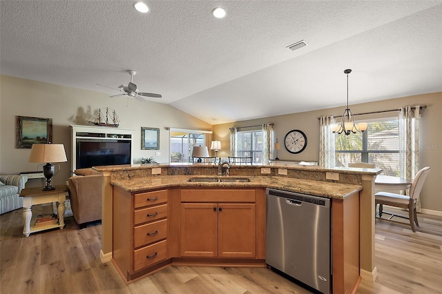 kitchen with a healthy amount of sunlight, an island with sink, stainless steel dishwasher, and lofted ceiling