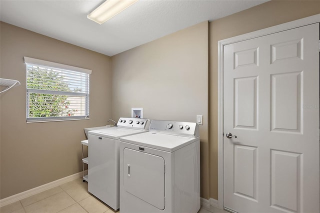 washroom featuring washer and clothes dryer and light tile patterned floors