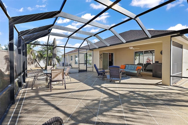 view of patio / terrace with an outdoor living space, ceiling fan, and a lanai