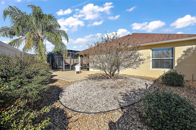 rear view of property featuring a patio and glass enclosure