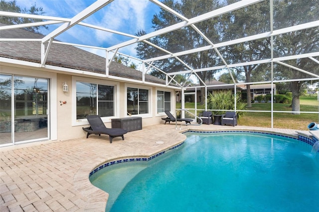 view of pool featuring pool water feature, glass enclosure, and a patio