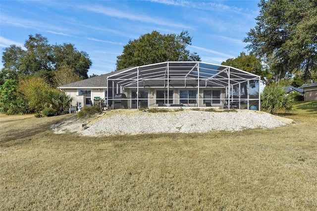 back of property with glass enclosure and a yard