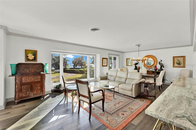 living room featuring crown molding, dark wood-type flooring, and a notable chandelier