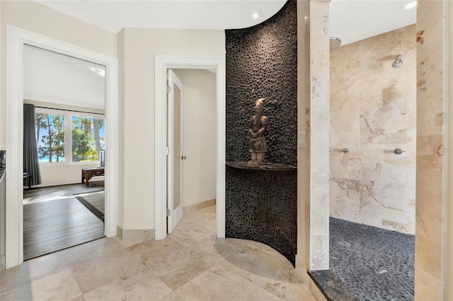 bathroom featuring hardwood / wood-style flooring and tiled shower