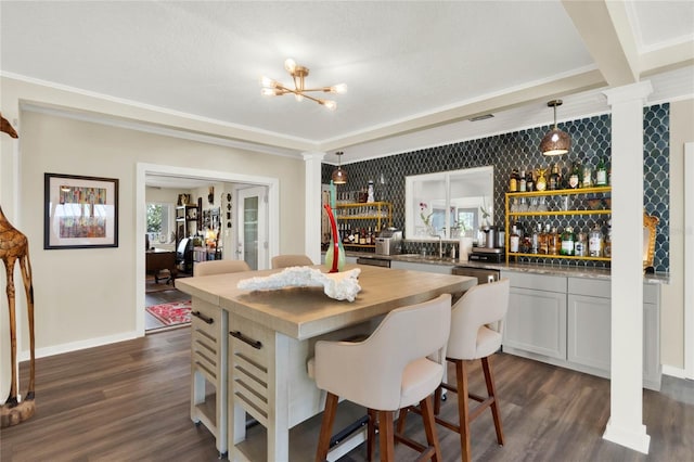 dining room featuring dark hardwood / wood-style floors, indoor wet bar, and a healthy amount of sunlight