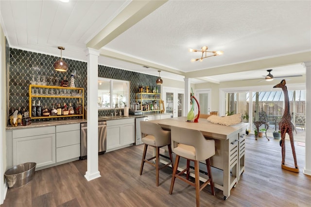 kitchen with white cabinetry, dishwasher, dark hardwood / wood-style floors, pendant lighting, and ceiling fan with notable chandelier