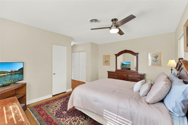 bedroom with ceiling fan, wood-type flooring, and a closet