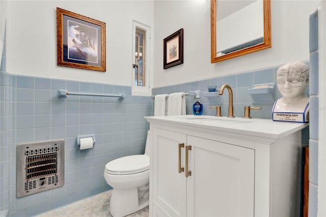 bathroom featuring vanity, toilet, tile walls, and heating unit