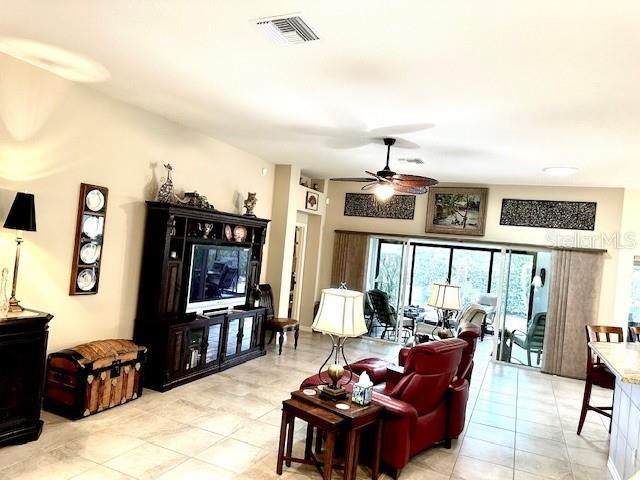 living room featuring light tile patterned floors and ceiling fan