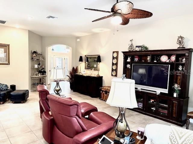 tiled living room with ceiling fan