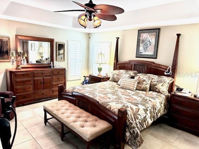 tiled bedroom featuring ceiling fan