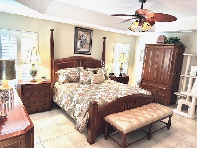 tiled bedroom featuring ceiling fan