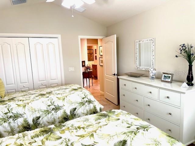 bedroom featuring ceiling fan, a closet, and lofted ceiling