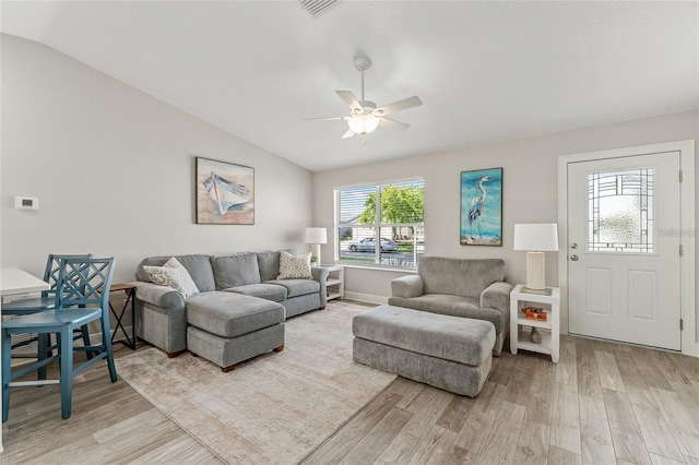 living room featuring light hardwood / wood-style flooring, vaulted ceiling, and ceiling fan