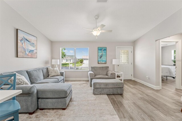 living room with light wood-type flooring and ceiling fan