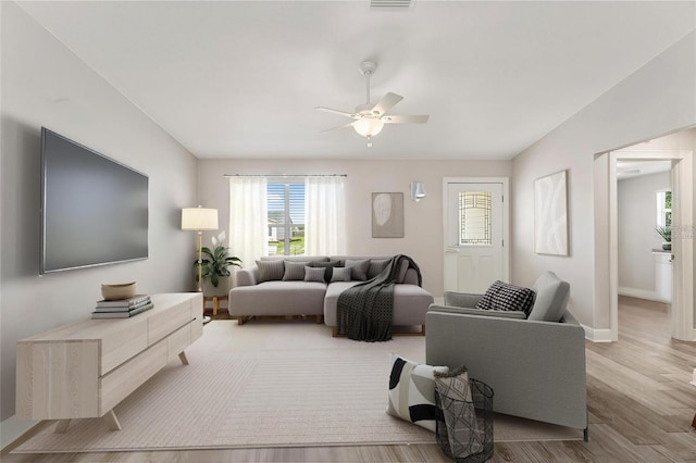 living room with ceiling fan and light wood-type flooring