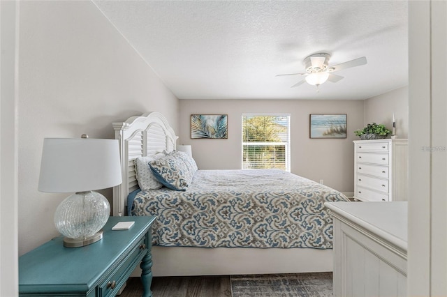 bedroom with a textured ceiling, dark hardwood / wood-style flooring, and ceiling fan