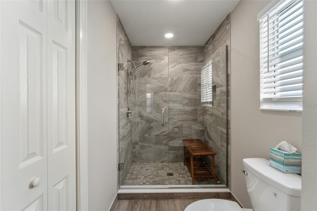 bathroom featuring hardwood / wood-style flooring, toilet, and walk in shower