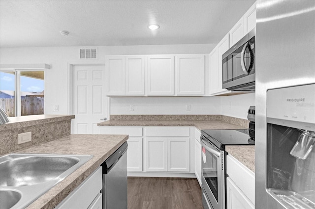 kitchen with white cabinetry, dark hardwood / wood-style floors, and appliances with stainless steel finishes