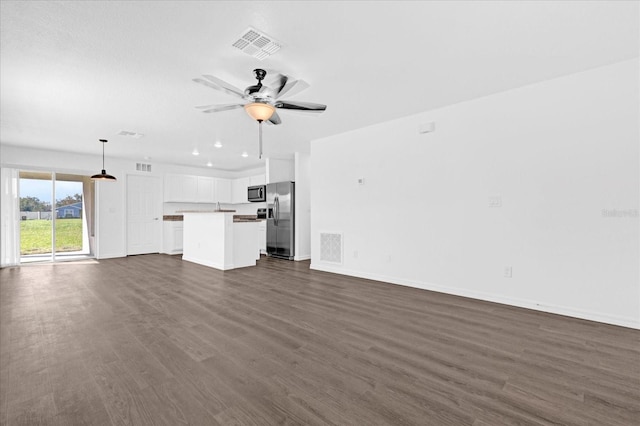 unfurnished living room with dark hardwood / wood-style floors and ceiling fan