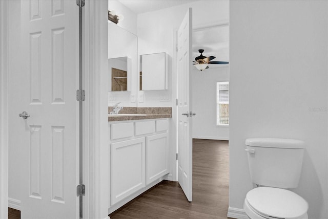 bathroom with vanity, hardwood / wood-style floors, ceiling fan, and toilet