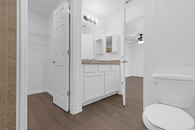 bathroom with vanity, hardwood / wood-style flooring, toilet, and ceiling fan