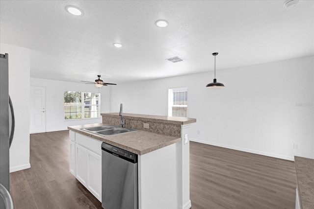 kitchen featuring sink, decorative light fixtures, an island with sink, stainless steel appliances, and white cabinets