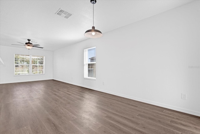 unfurnished room with ceiling fan, plenty of natural light, and dark hardwood / wood-style flooring