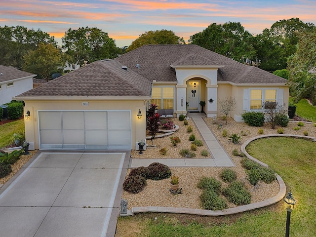 ranch-style house with a garage and a yard