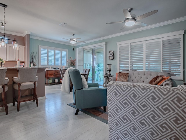 living room with ceiling fan, light hardwood / wood-style floors, and crown molding