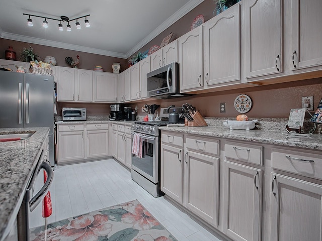 kitchen with white cabinets, appliances with stainless steel finishes, light stone counters, and ornamental molding