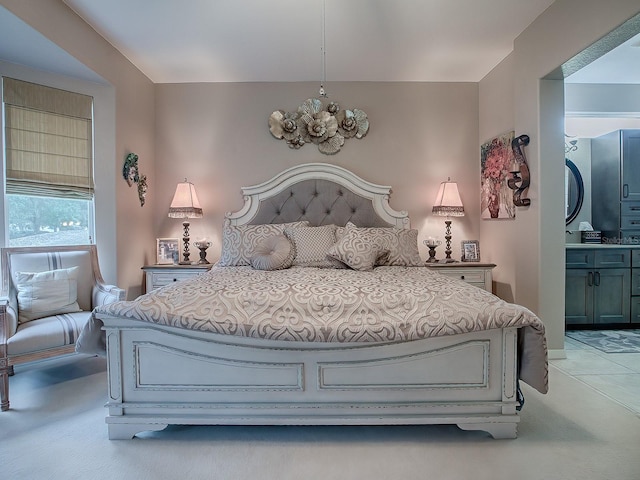 bedroom featuring ensuite bath and light colored carpet