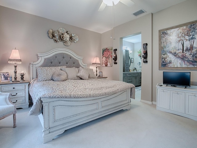 bedroom featuring light carpet, ensuite bath, and ceiling fan