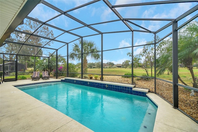 view of pool with glass enclosure and a patio area