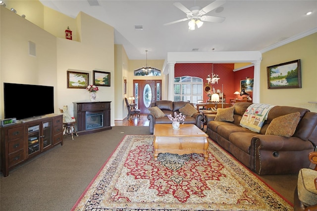 living room featuring ornate columns, crown molding, carpet, and ceiling fan with notable chandelier