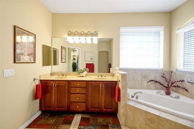 bathroom featuring tiled bath and vanity