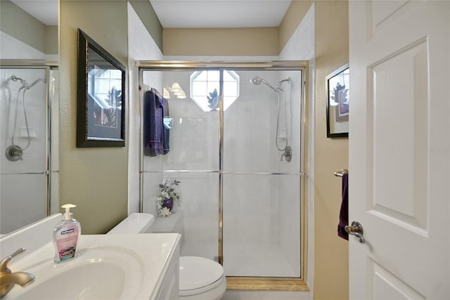 bathroom with toilet, an enclosed shower, and vanity