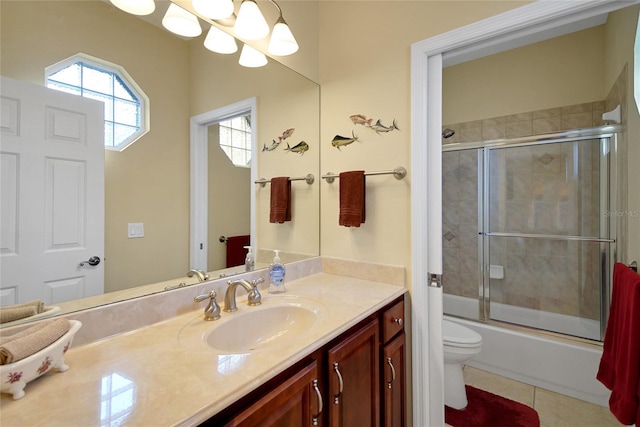 full bathroom with tile patterned flooring, vanity, enclosed tub / shower combo, and toilet