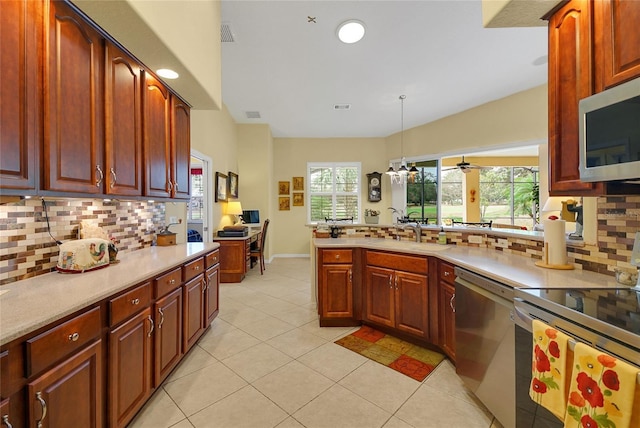 kitchen with pendant lighting, stainless steel appliances, tasteful backsplash, and sink