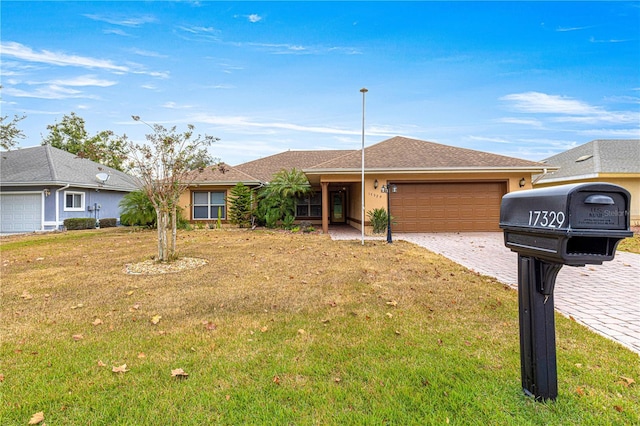 single story home featuring a garage and a front yard