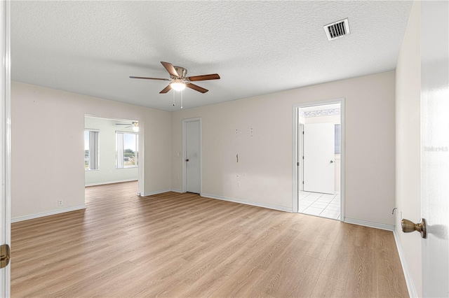 unfurnished room featuring a textured ceiling, light hardwood / wood-style floors, and ceiling fan