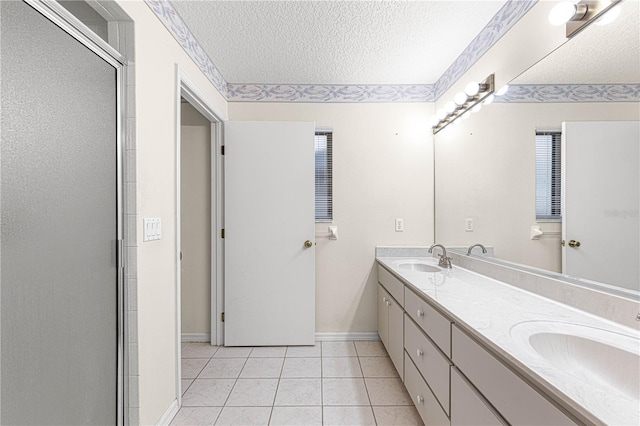 bathroom featuring tile patterned flooring, vanity, an enclosed shower, and a textured ceiling