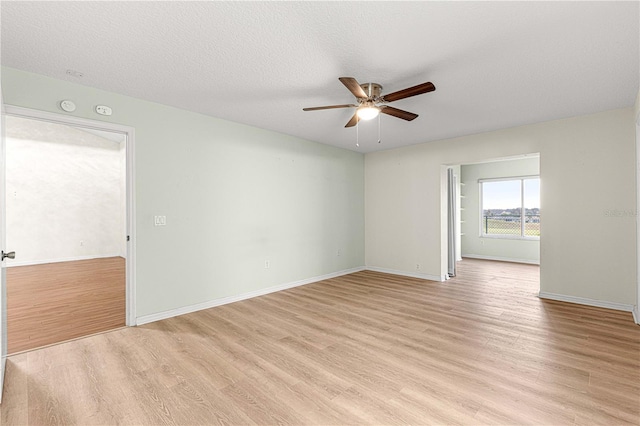 empty room with ceiling fan, a textured ceiling, and light hardwood / wood-style flooring