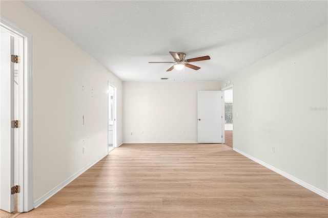 empty room featuring a textured ceiling, light hardwood / wood-style floors, and ceiling fan