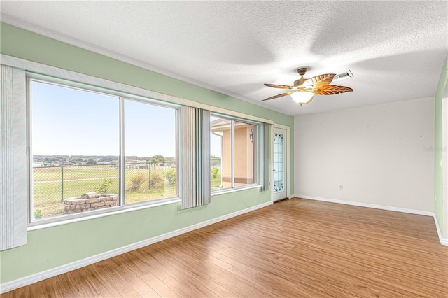 spare room with ceiling fan, wood-type flooring, and a textured ceiling